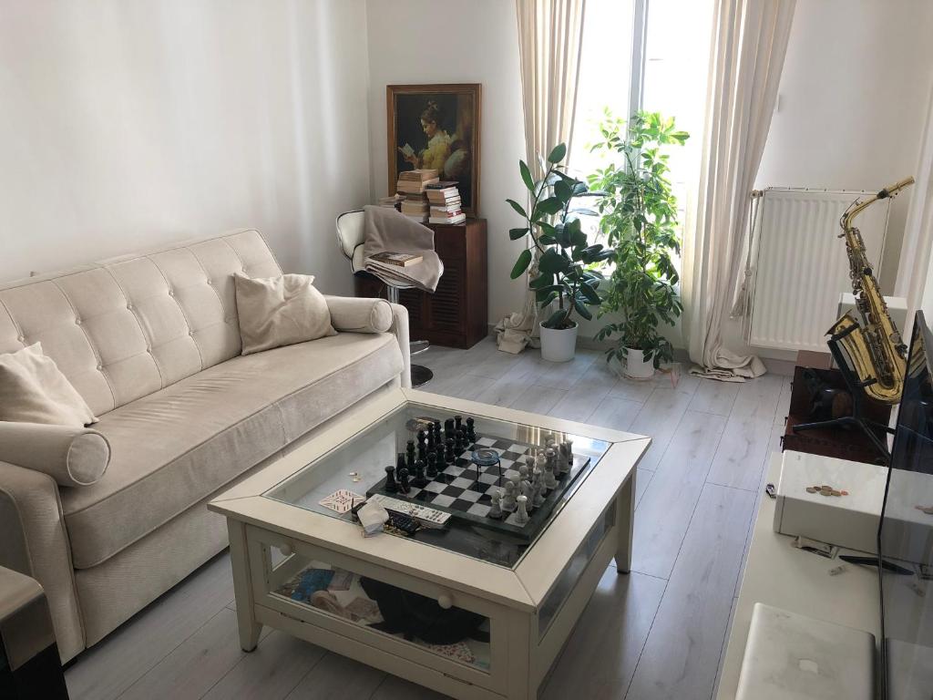- un salon avec un canapé et un échiquier sur une table dans l'établissement Upper West Side XVI Golden Triangle Cozy Flat, à Paris