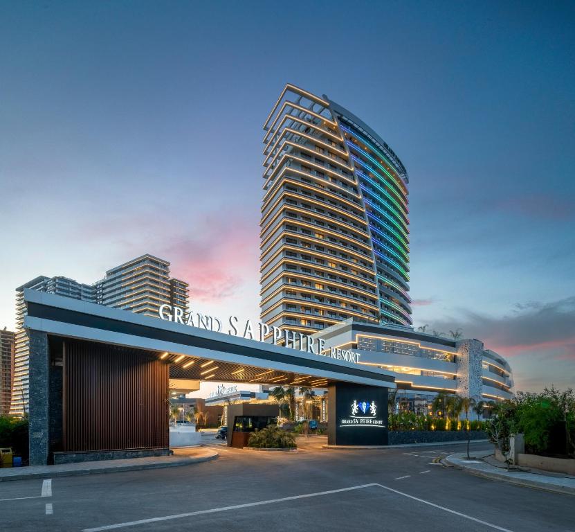 Grand Sapphire Resort & Casino في Trikomo: مبنى كبير وامامه موقف سيارات