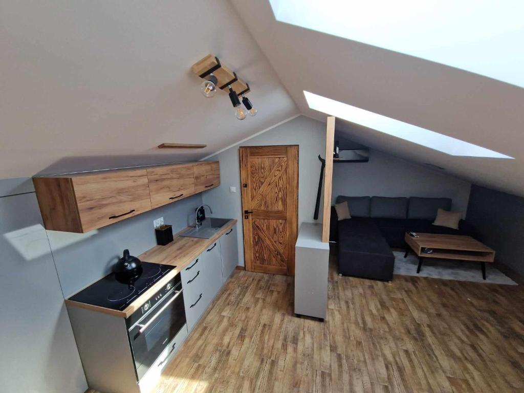 eine Küche mit Herd und Sofa in einem Zimmer in der Unterkunft Apartament Gorzków 