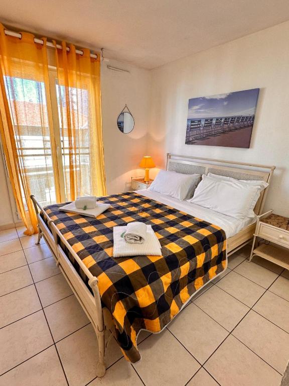 une chambre avec un grand lit avec une couverture à carreaux dans l'établissement Suite DES DOMES FSHH, à Nice