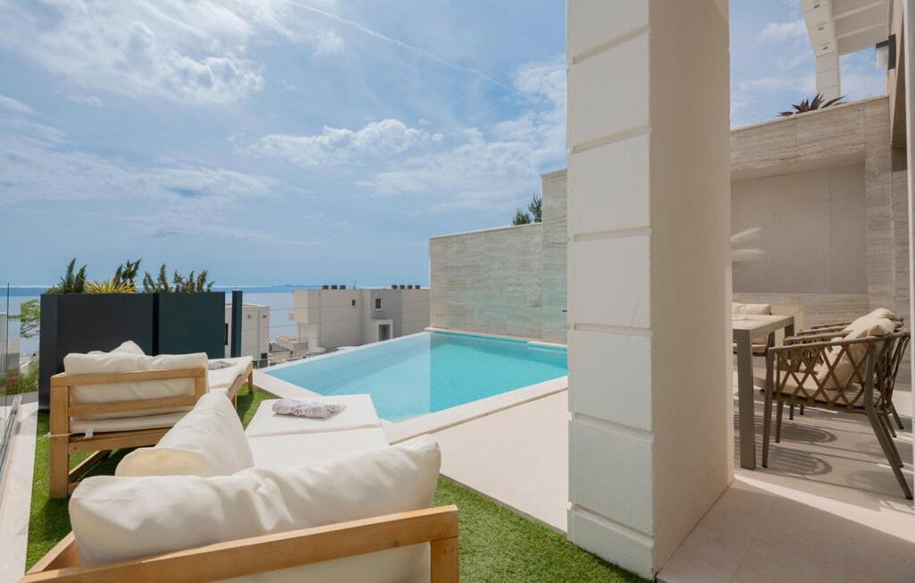 einen Balkon mit einem Pool und einer Terrasse in der Unterkunft Villa Rosemary 2 in Makarska