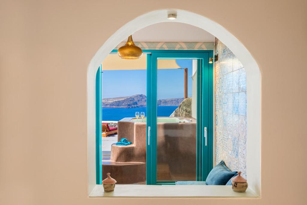 a bathroom with a tub and a view of the ocean at Akron Terra Houses in Akrotiri