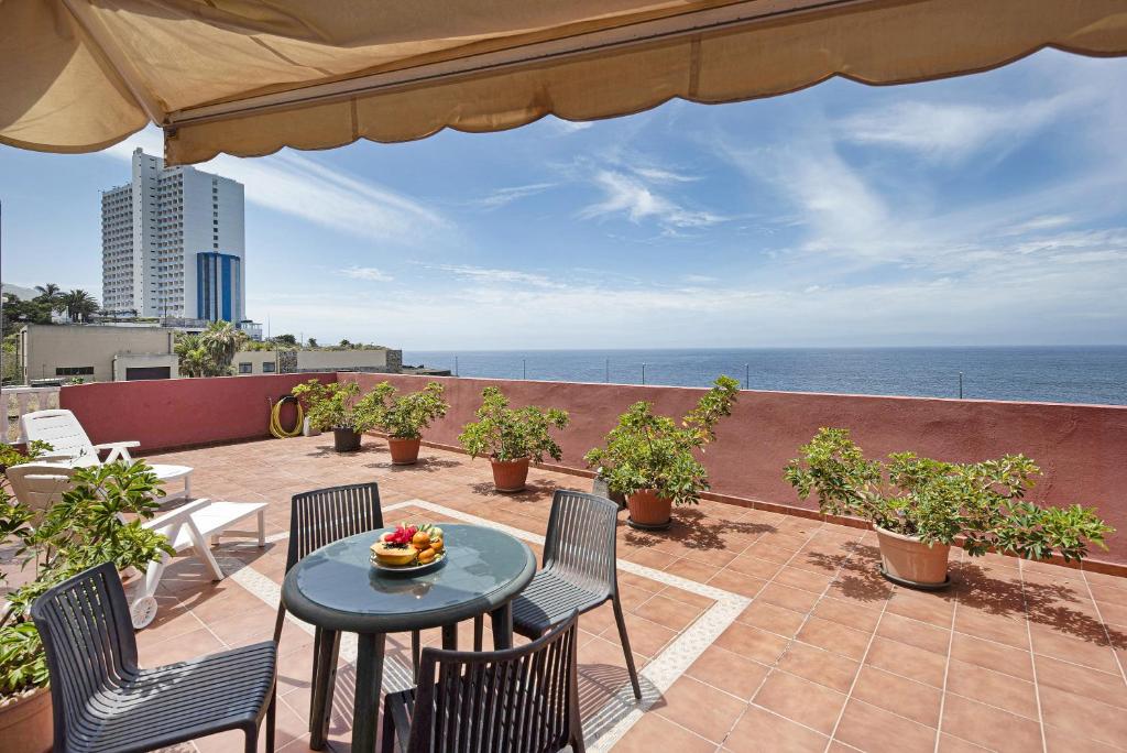 a patio with a table and chairs and the ocean at Bonito apart sea view playa jardin in Puerto de la Cruz