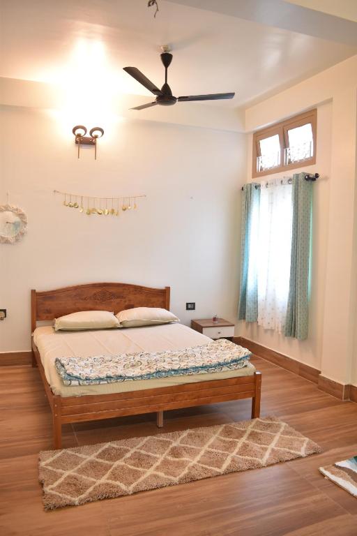 Schlafzimmer mit einem Bett und einem Deckenventilator in der Unterkunft Axom Aura in Tezpur