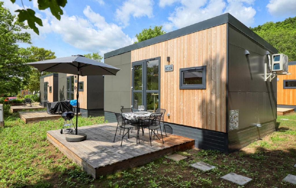 a tiny house with a table and an umbrella at Tiny House Wemding in Wemding