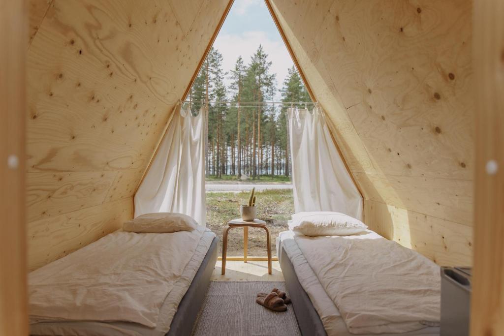 twee bedden in een tent met een raam bij Pistocamp in Puumala