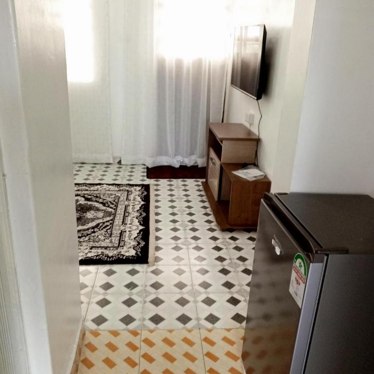 une cuisine avec un sol en damier et une télévision dans l'établissement Nakuru Residential and Fully Furnished Apartments Behind Hill Court Hotel at St Mary's pastoral center, à Kerita