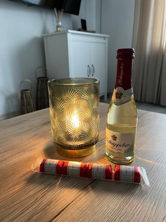 una botella de champán y una copa en una mesa en Maja Appartement, en Bad Schwartau