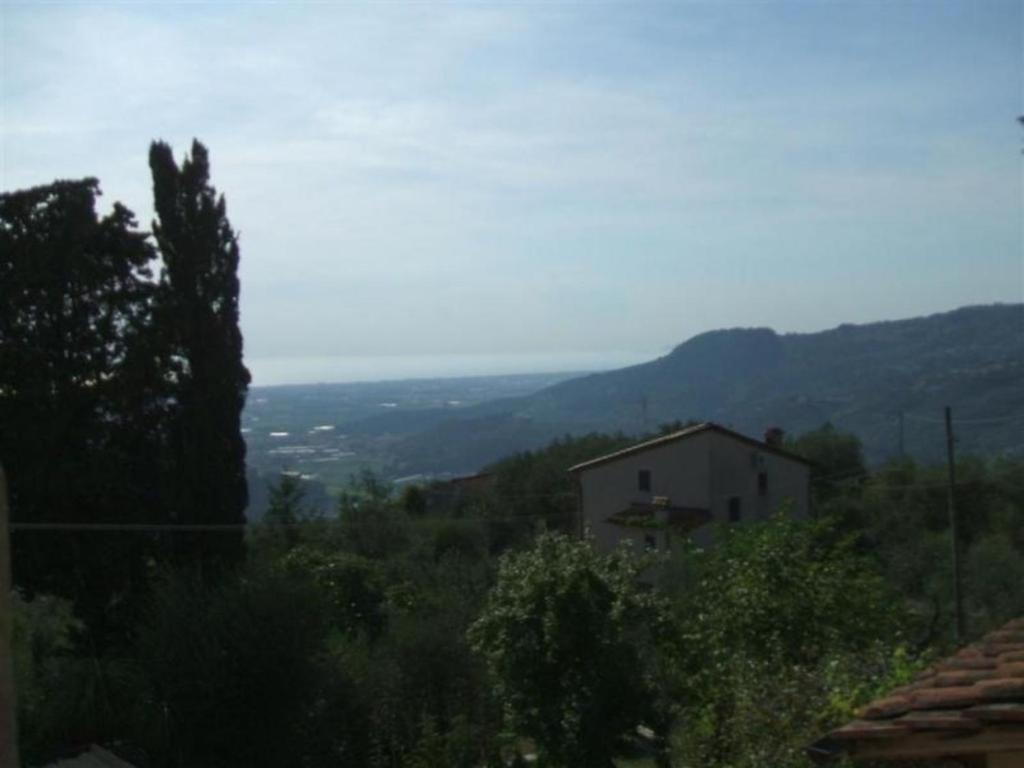 een huis op een heuvel met bergen in de verte bij Gemütliches Landhaus in ruhiger Lage mit herrlicher Pergola und Blick bis zur Küste in Montigiano