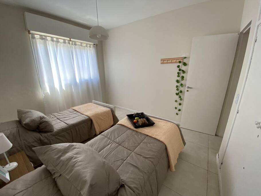 ein Wohnzimmer mit 2 Betten und einem Sofa in der Unterkunft Alójate en el corazón de Trelew, cerca de todo! in Trelew