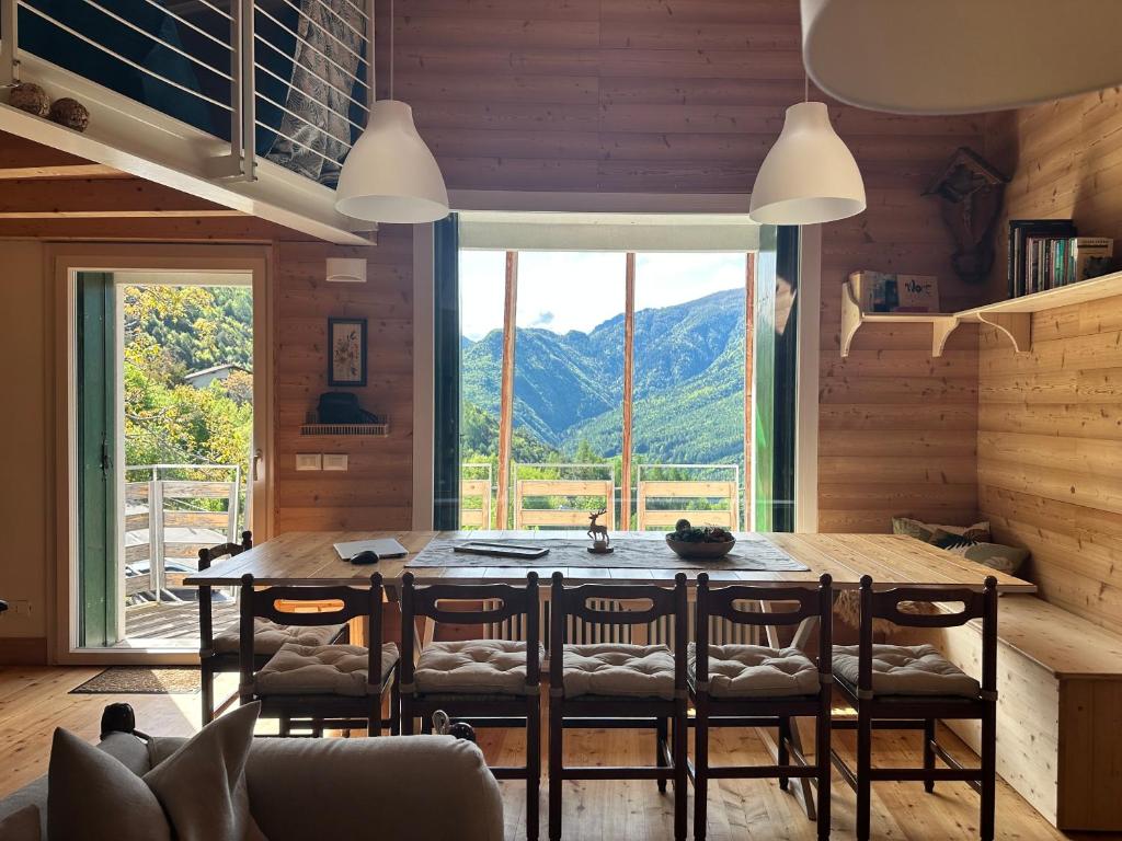 a dining room with a table and chairs and a large window at CIELO E TERRA Chalet Zencheri con vista panoramica in Piazza