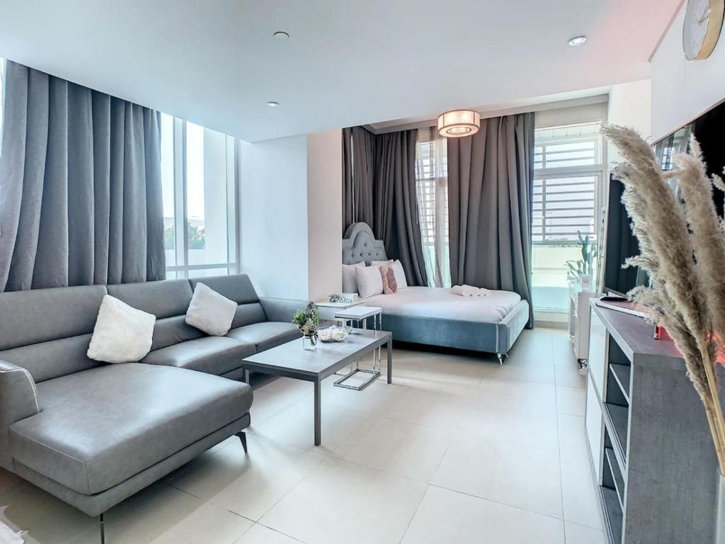 een woonkamer met een bank en een bed bij Key View - Hilliana Tower in Dubai