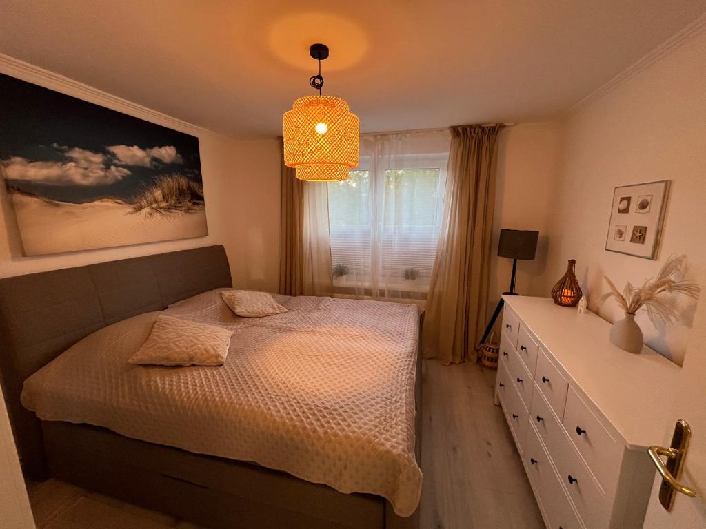 a bedroom with a bed and a dresser and a window at Maja Appartement in Bad Schwartau