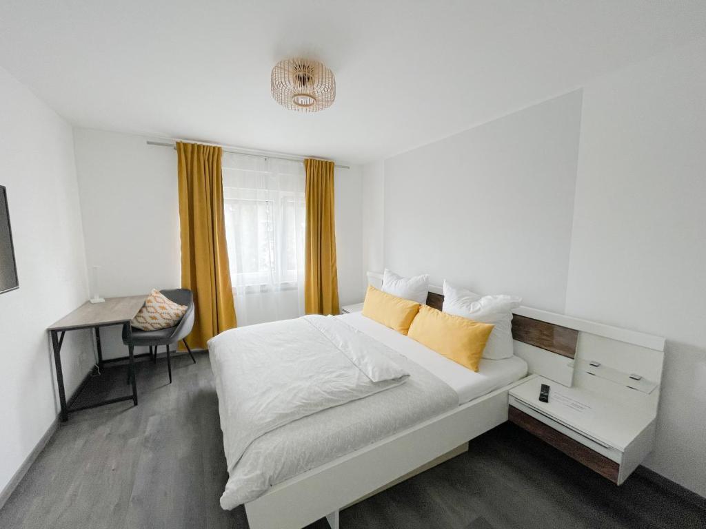 a white bed with yellow pillows in a bedroom at Wohlfühloase im Traum-Apart in Essen