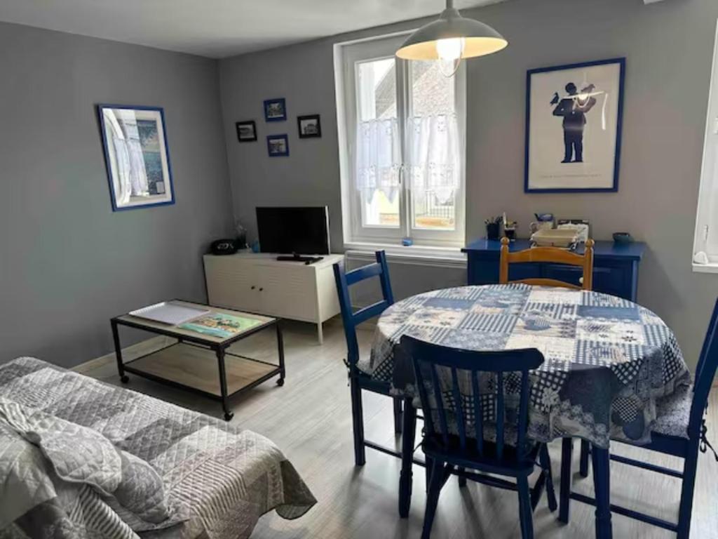 - un salon avec une table, une table et des chaises dans l'établissement Appartement proche centre, à Dinard