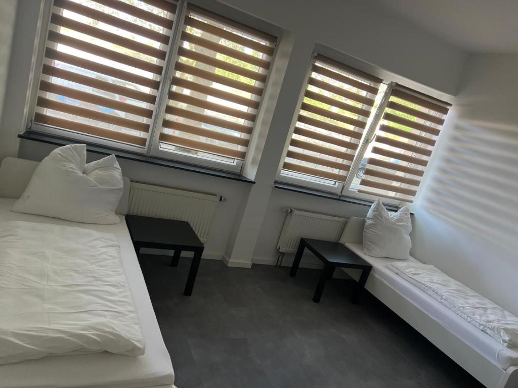 una camera con due letti e due tavoli e finestre di Adar ad Hannover