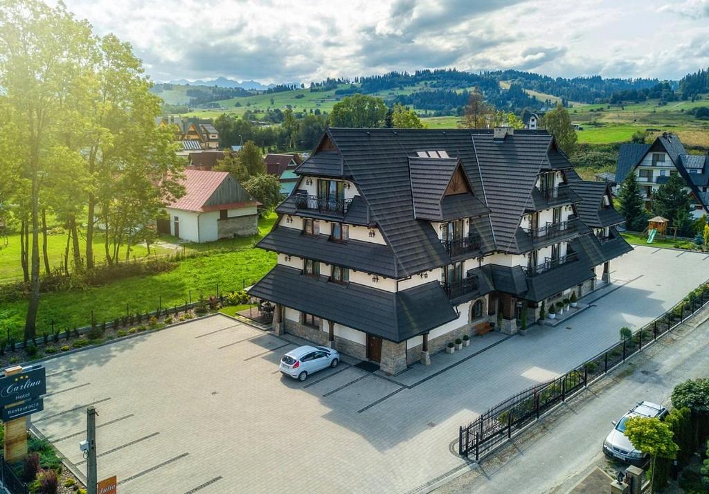 an aerial view of a large house with a parking lot at Hotel Carlina in Białka Tatrzanska