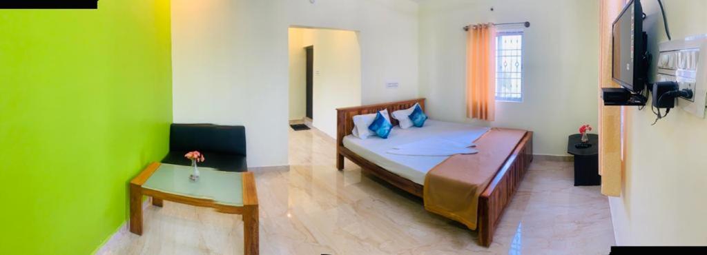 a bedroom with a bed and a green wall at New green hotel in Yelagiri
