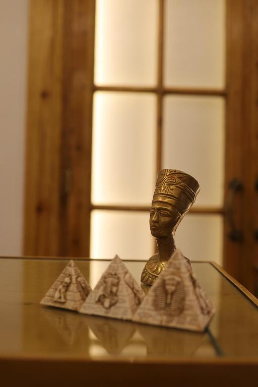 una estatua sentada en una mesa de cristal con en Champollion Palace en El Cairo
