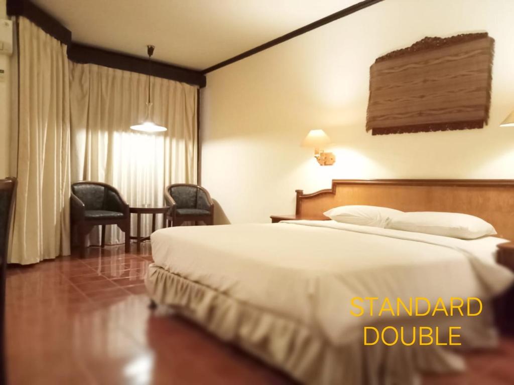 um quarto de hotel com uma cama e uma mesa em A' Bahtera Residence em Klandasan Kecil