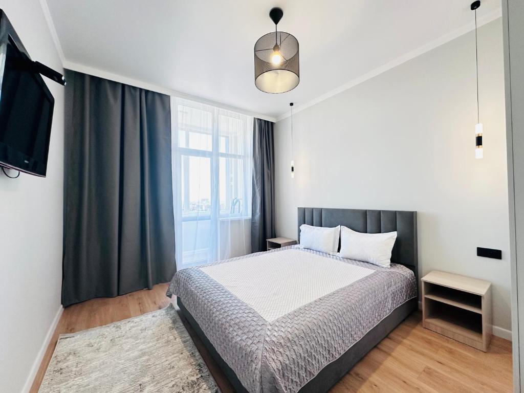 1 dormitorio con cama y ventana grande en ЖК "Бухар жырау эксклюзив" Люксовые апартаменты en Astaná