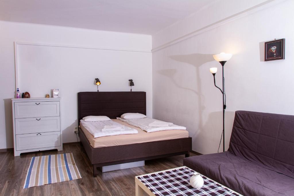 a small bedroom with a bed and a couch at Hedgehog Apartment near Margaret Island in Budapest