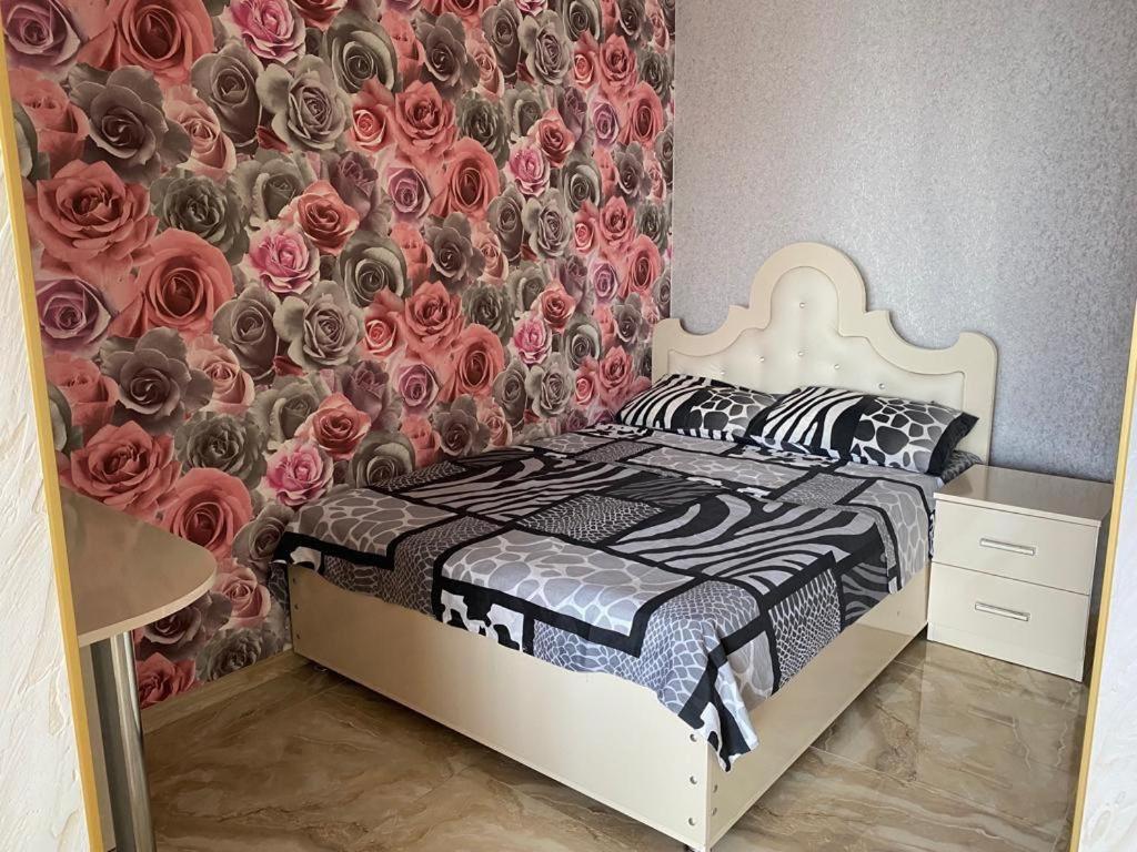 een slaapkamer met een bed met bloemenbehang bij Art comfort in Rustavi