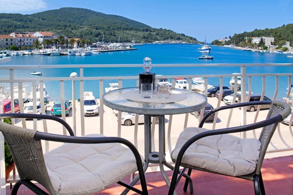 un tavolo su un balcone con vista su un porto turistico di Sunshine Apartment Doda a Vela Luka (Vallegrande)