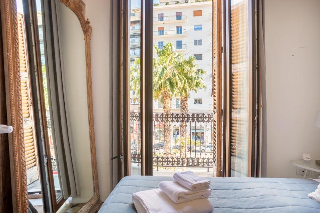 een slaapkamer met een bed en een groot raam bij Bari LandLord 71 - SELF CHECK IN in Bari