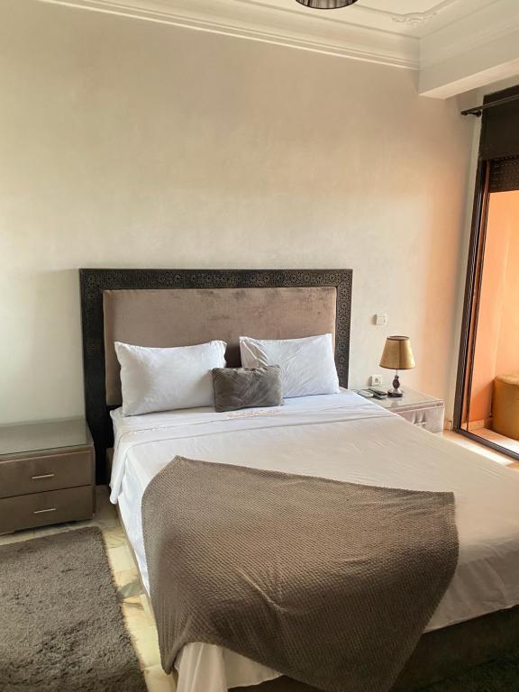 um quarto com uma grande cama branca num quarto em Dar Yasmine em Marrakech