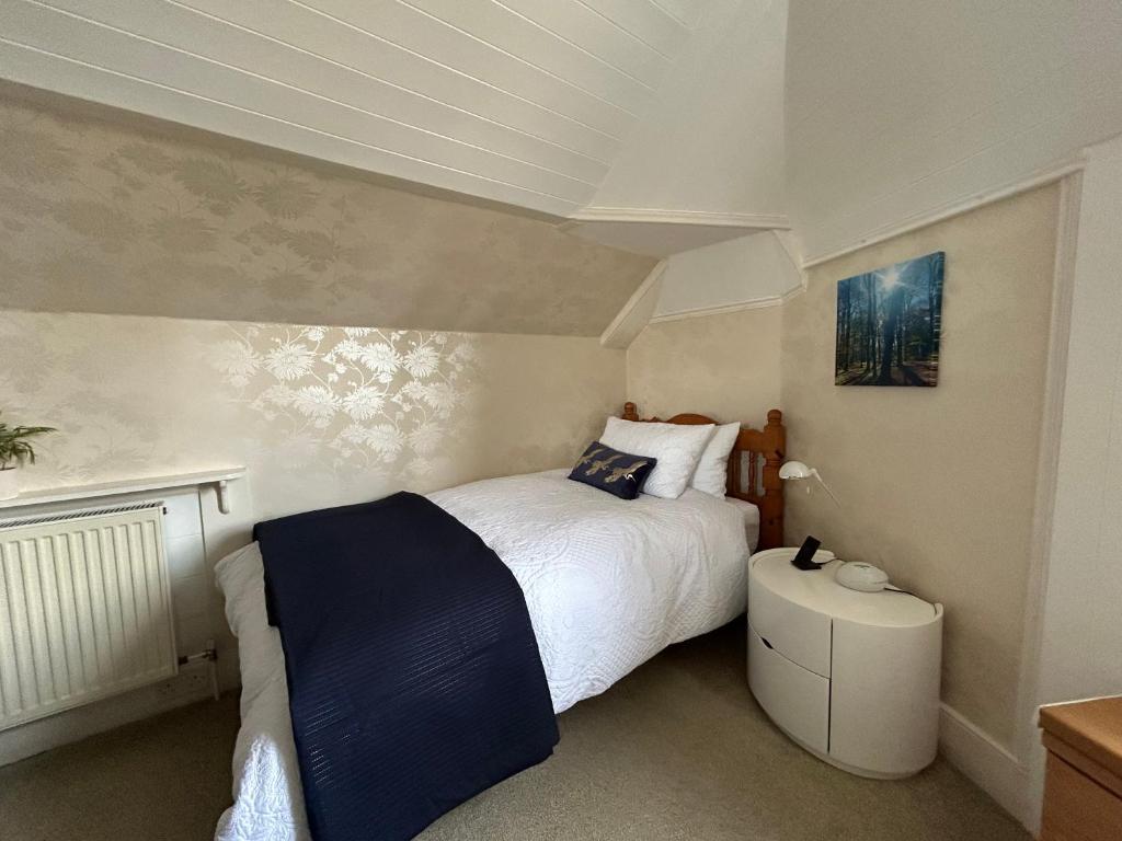 um quarto com uma cama grande e um cobertor azul em Glen Lyon Lodge Bed and Breakfast em Nairn