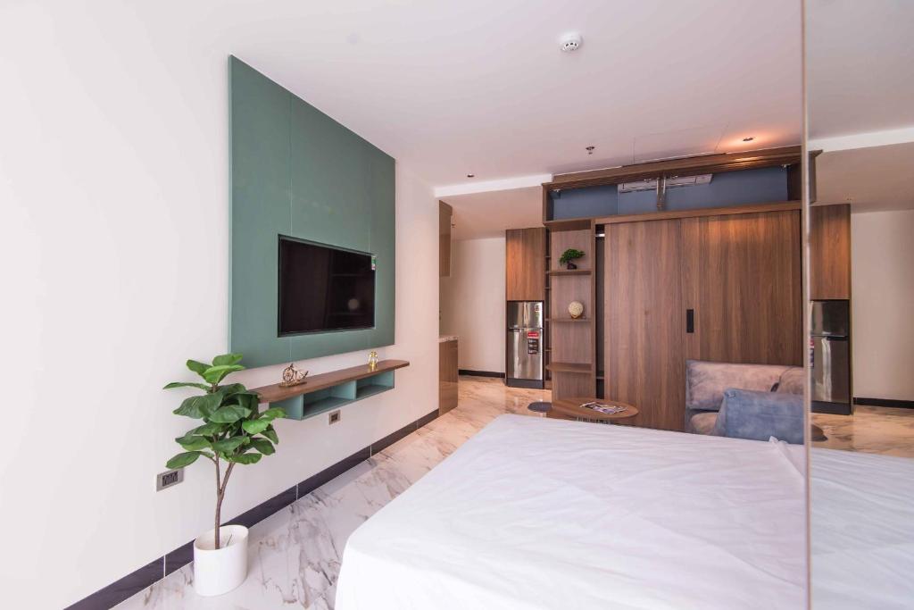 a bedroom with a large white bed and a tv at Luxe Paradise Suites Hotel Hoang Cau in Hanoi