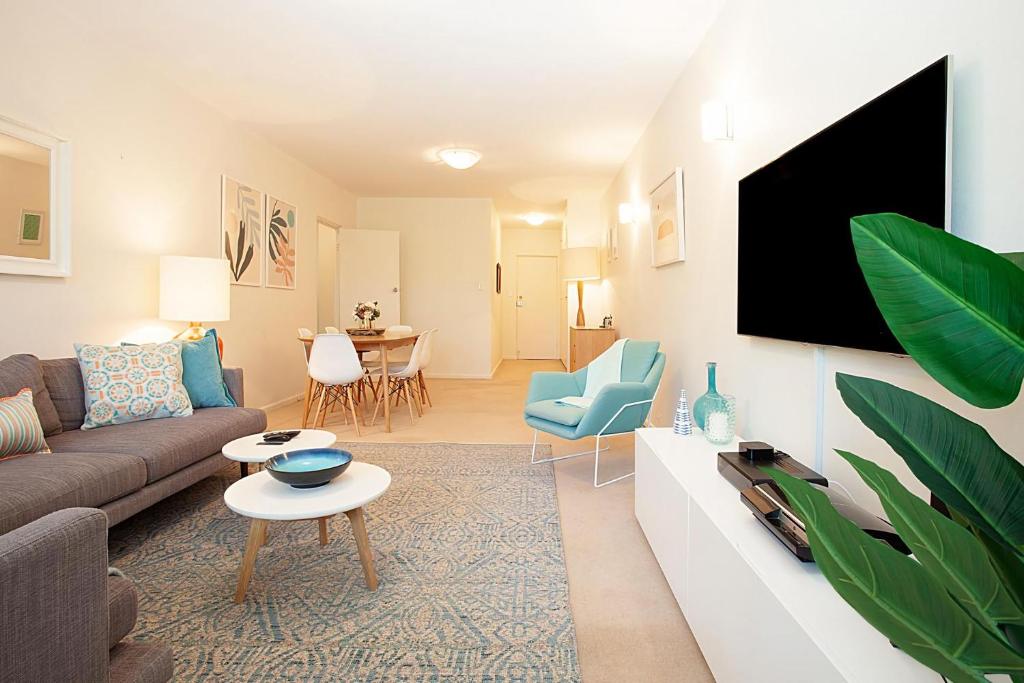 a living room with a couch and a tv at Bayside Tranquility in Sydney