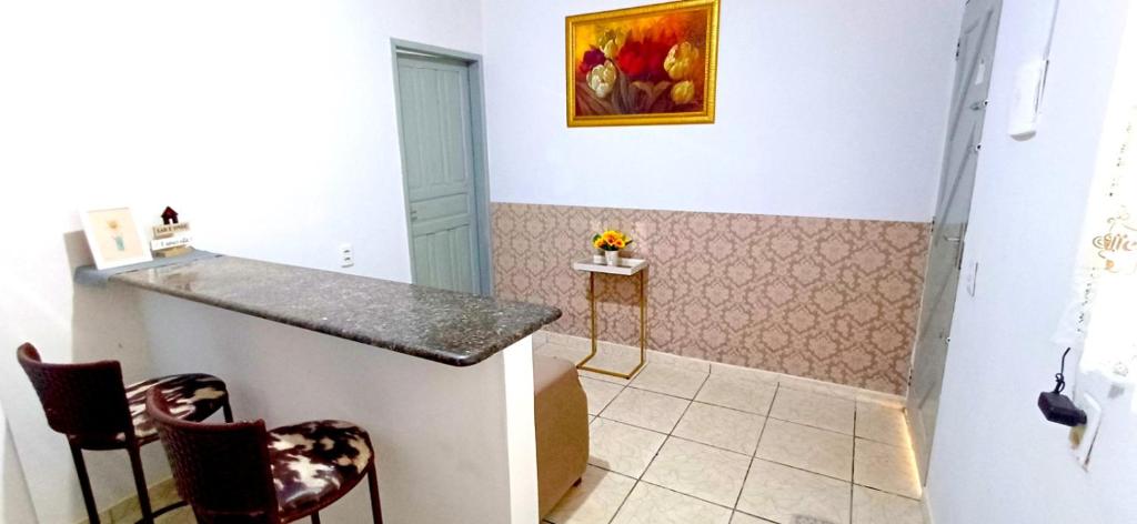 a bathroom with a counter and two chairs in a room at Flat JM in Parauapebas