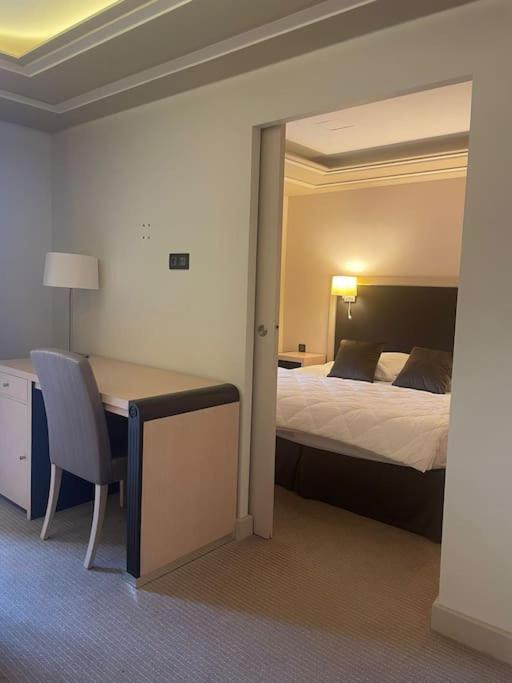 une chambre d'hôtel avec un lit et un bureau et une chambre dans l'établissement Sydney, à Juvignac
