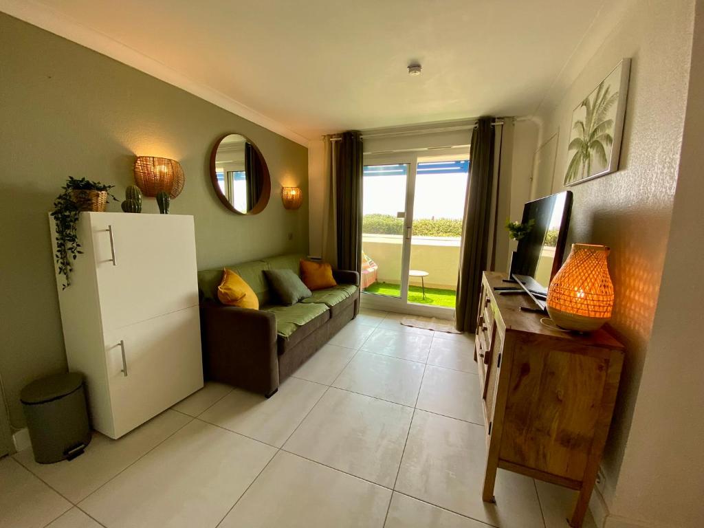 - un salon avec un canapé et un réfrigérateur dans l'établissement Charmant appartement en front de mer avec piscine, à Lacanau-Océan