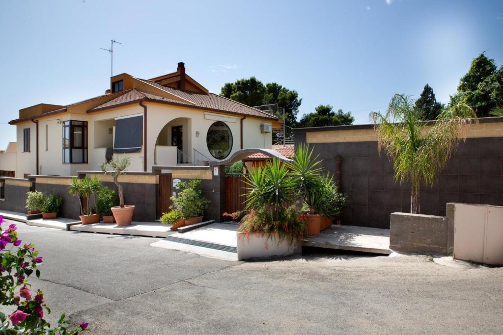 una casa con macetas delante de una valla en B&B Il Mandorlo, en Sciacca