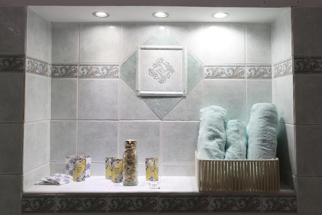 a bathroom with a shelf with towels and a mirror at Loft Piazza Cavour Vercelli in Vercelli