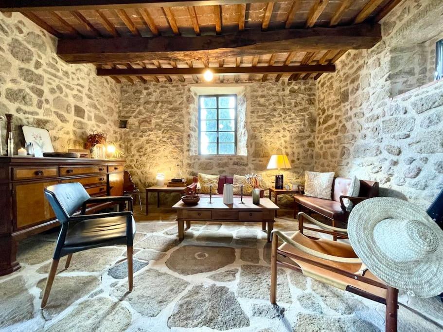 a living room filled with furniture and a stone wall at Casa Vista Maremma Tuscany in Roccatederighi