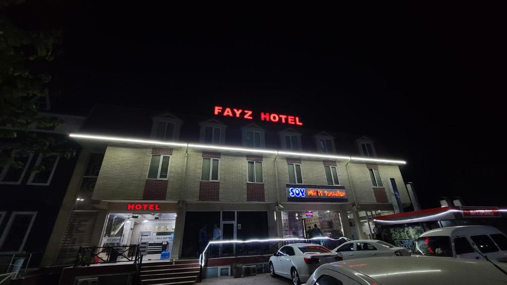 ein schickes Hotel mit Neonschild darüber in der Unterkunft FAYZ HOTEL in Karmana