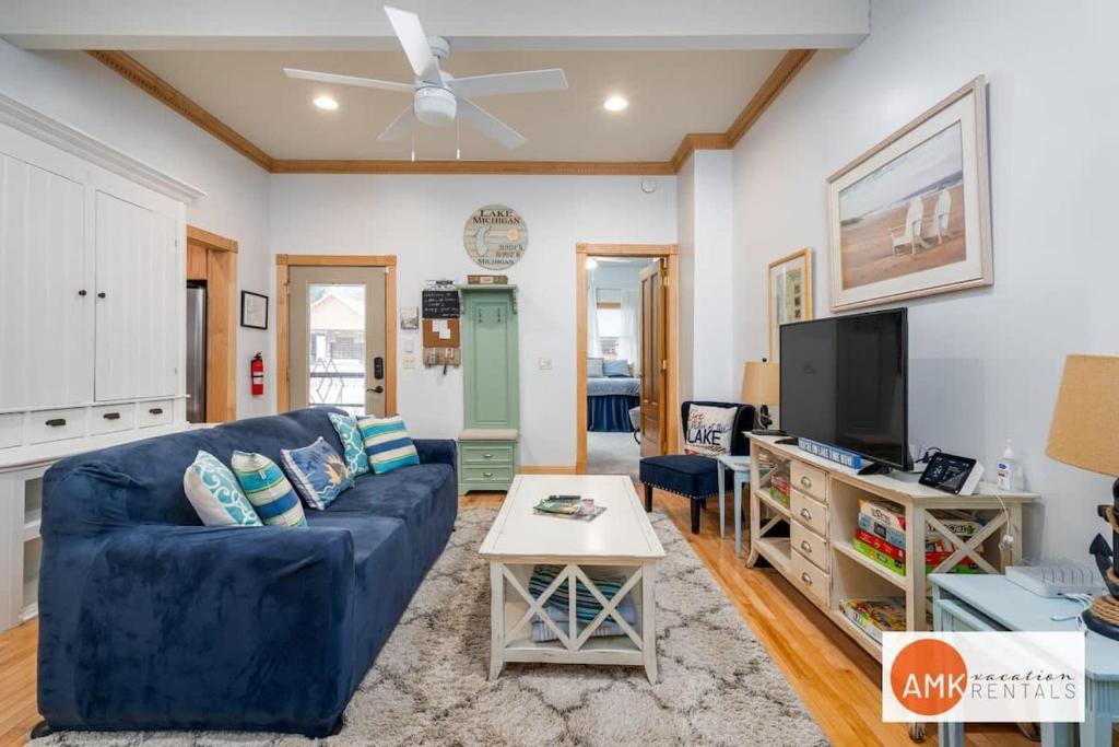 a living room with a blue couch and a tv at Lake Life Getaway - Condo near downtown! in Douglas