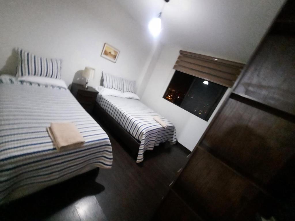 a bedroom with two beds and a window at Ámbar B3-P15-TC in Cochabamba