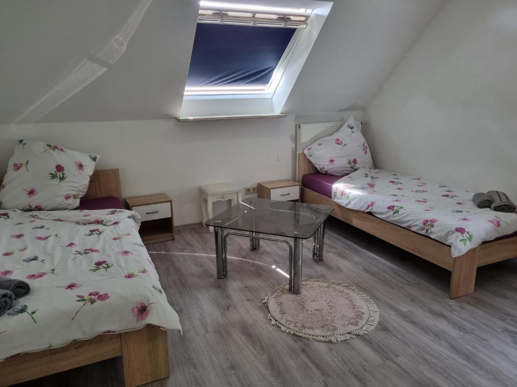 mały pokój z 2 łóżkami i szklanym stołem w obiekcie Gasthaus Weigl w mieście Großmehring