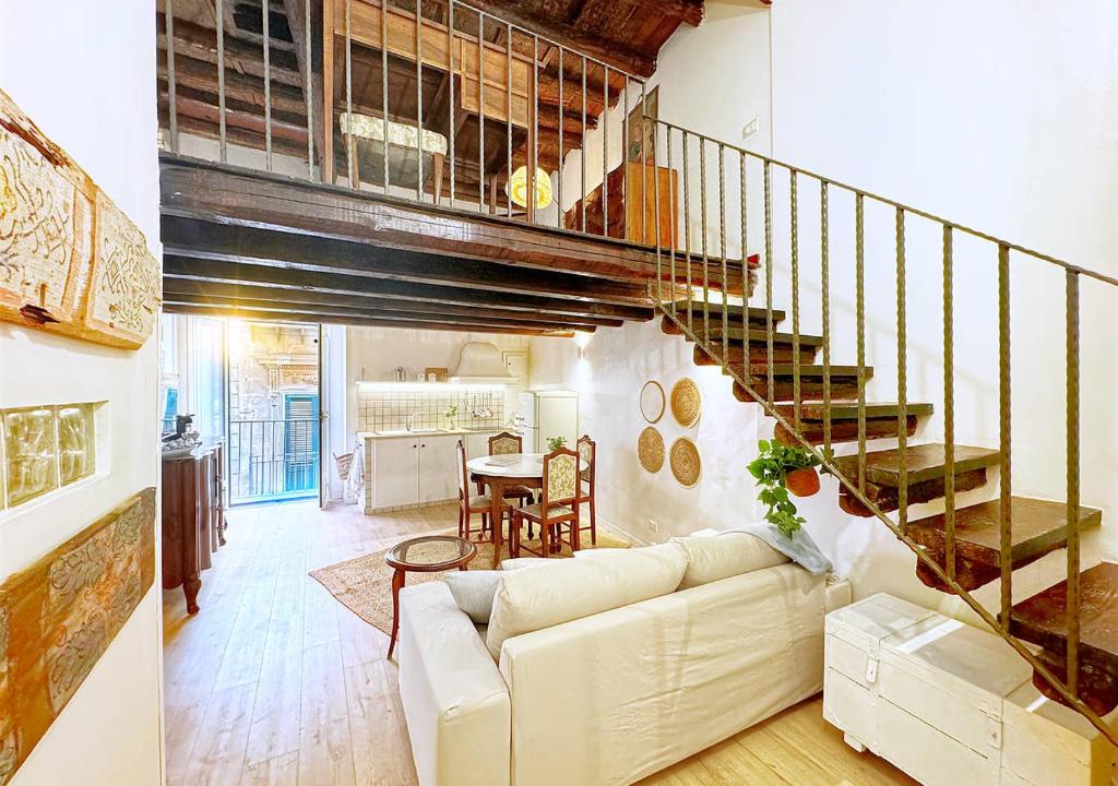 a living room with a white couch and a spiral staircase at Solemar Sicilia - Casa Enrica in Palermo