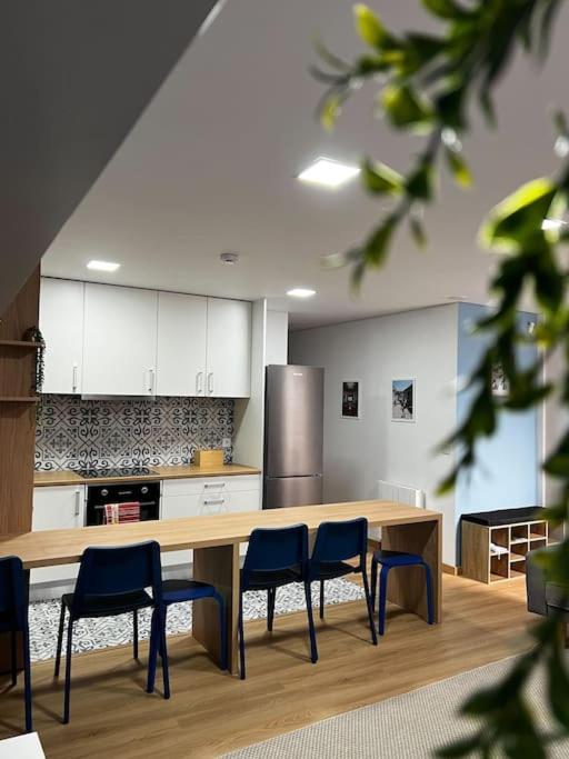 a kitchen with a table and chairs and a refrigerator at Apartamento Matriz PVZ (T2) in Póvoa de Varzim