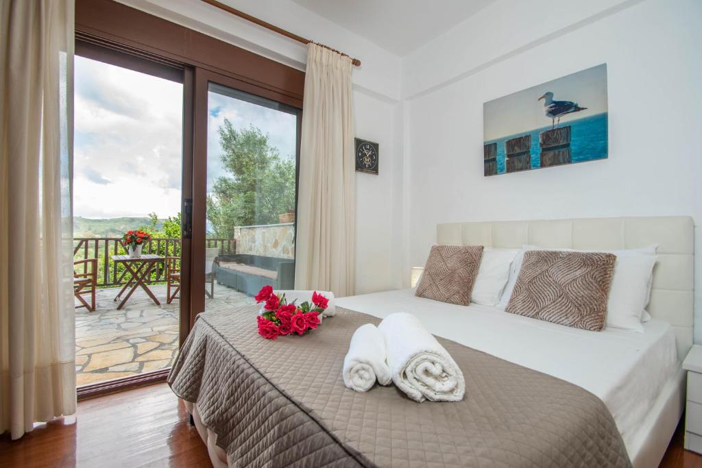 1 dormitorio con 1 cama con toallas y balcón en The Stone House en Áyios Dhimítrios