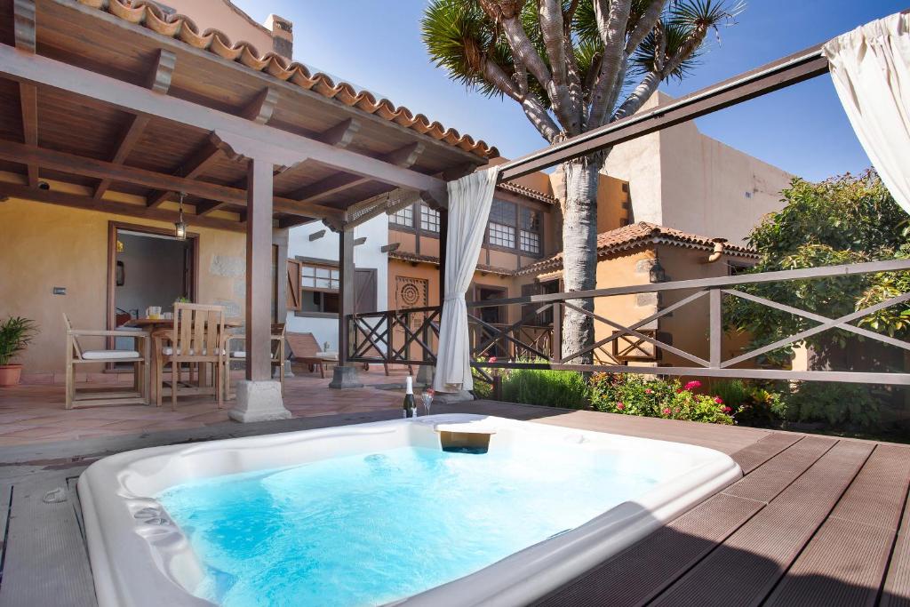 una vasca idromassaggio su una terrazza con una casa di La casona de la rambla a San Juan de la Rambla