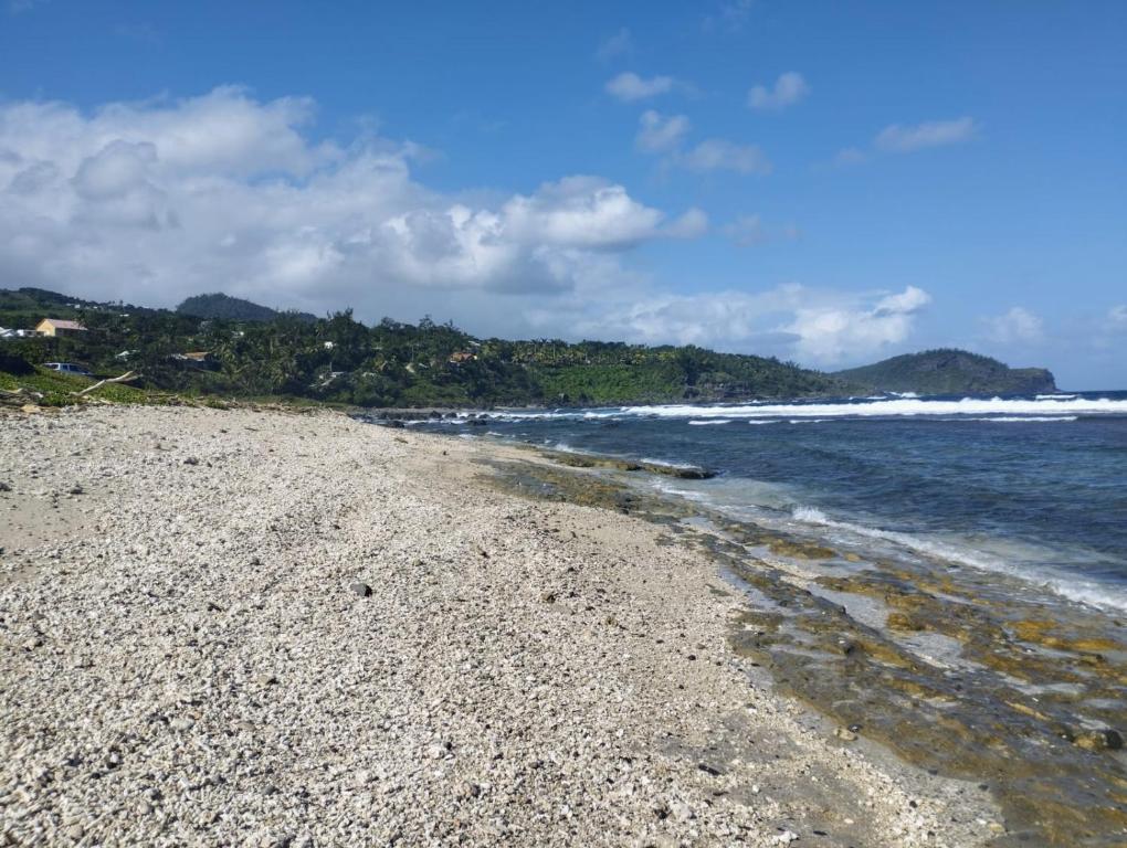 a beach with a rocky shore and the ocean at CASA COLIVING avec chambre salle de bain individuelles privatives in Saint-Pierre