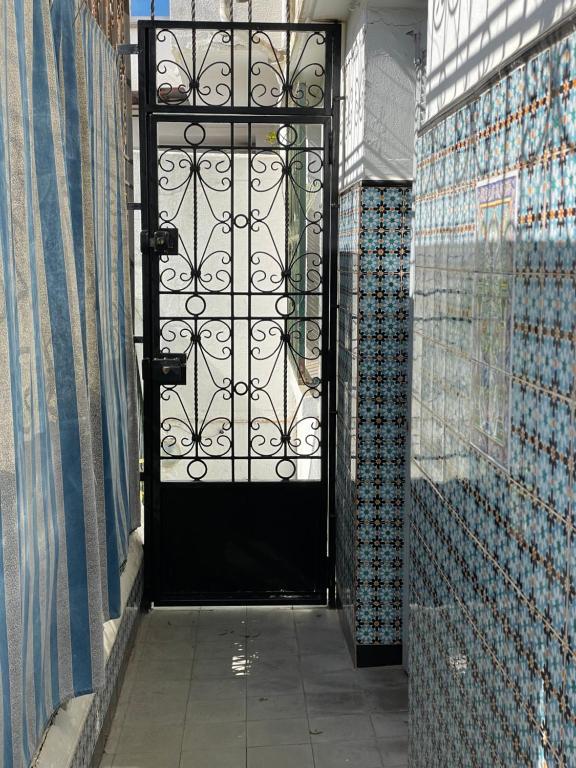 a black door in a room with tiles on the walls at chambre standard elbiar in El Biar