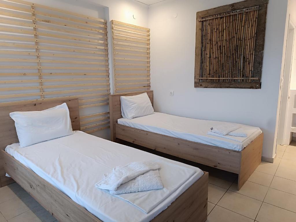 two twin beds in a room with a window at Salty SeaShells Skiathos in Skiathos